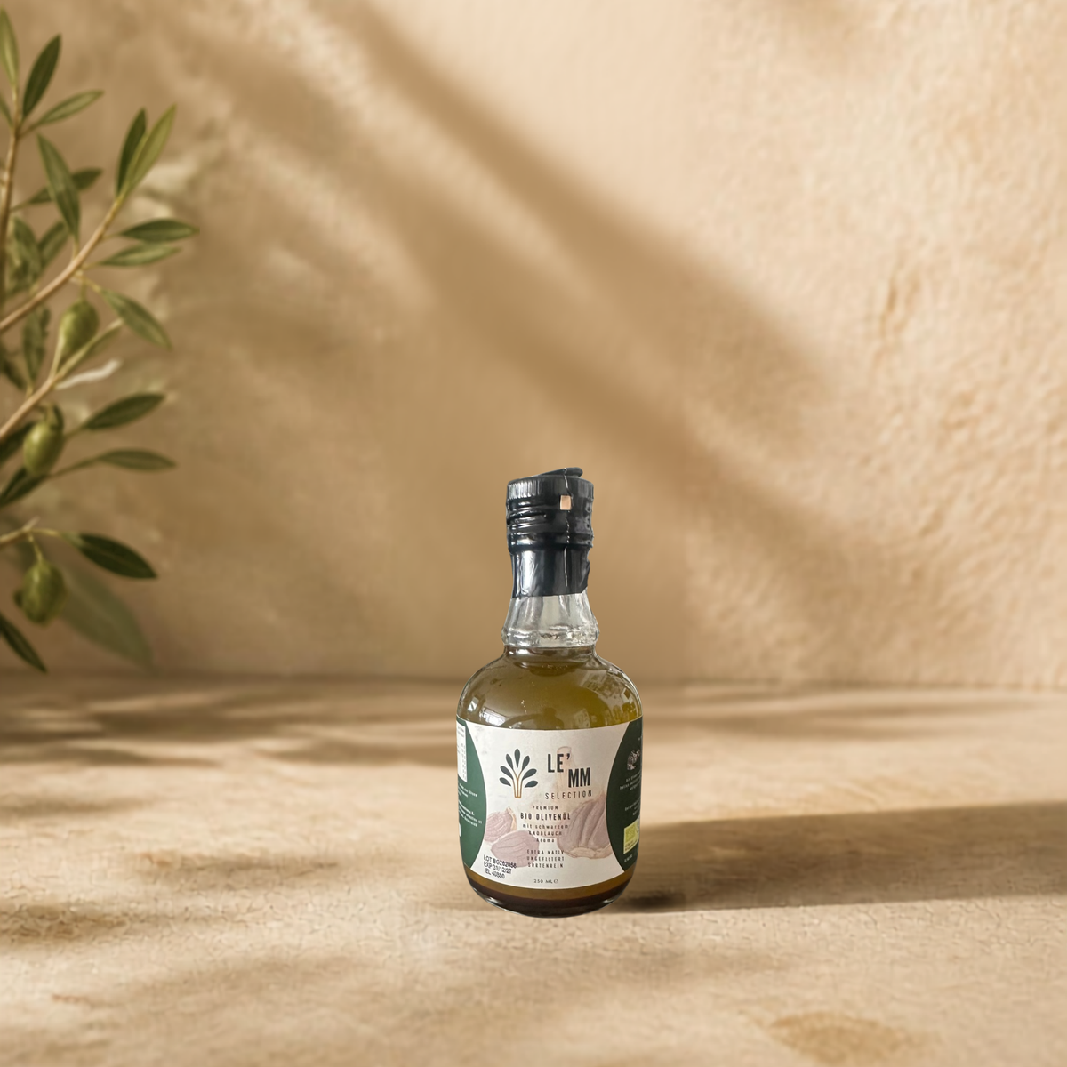 Griechisches Bio Olivenöl Extra Nativ mit fermentiertem Knoblauch Geschmack von LEMM Selection in mediterranem Ambiente mit Olivenzweig vorderseite