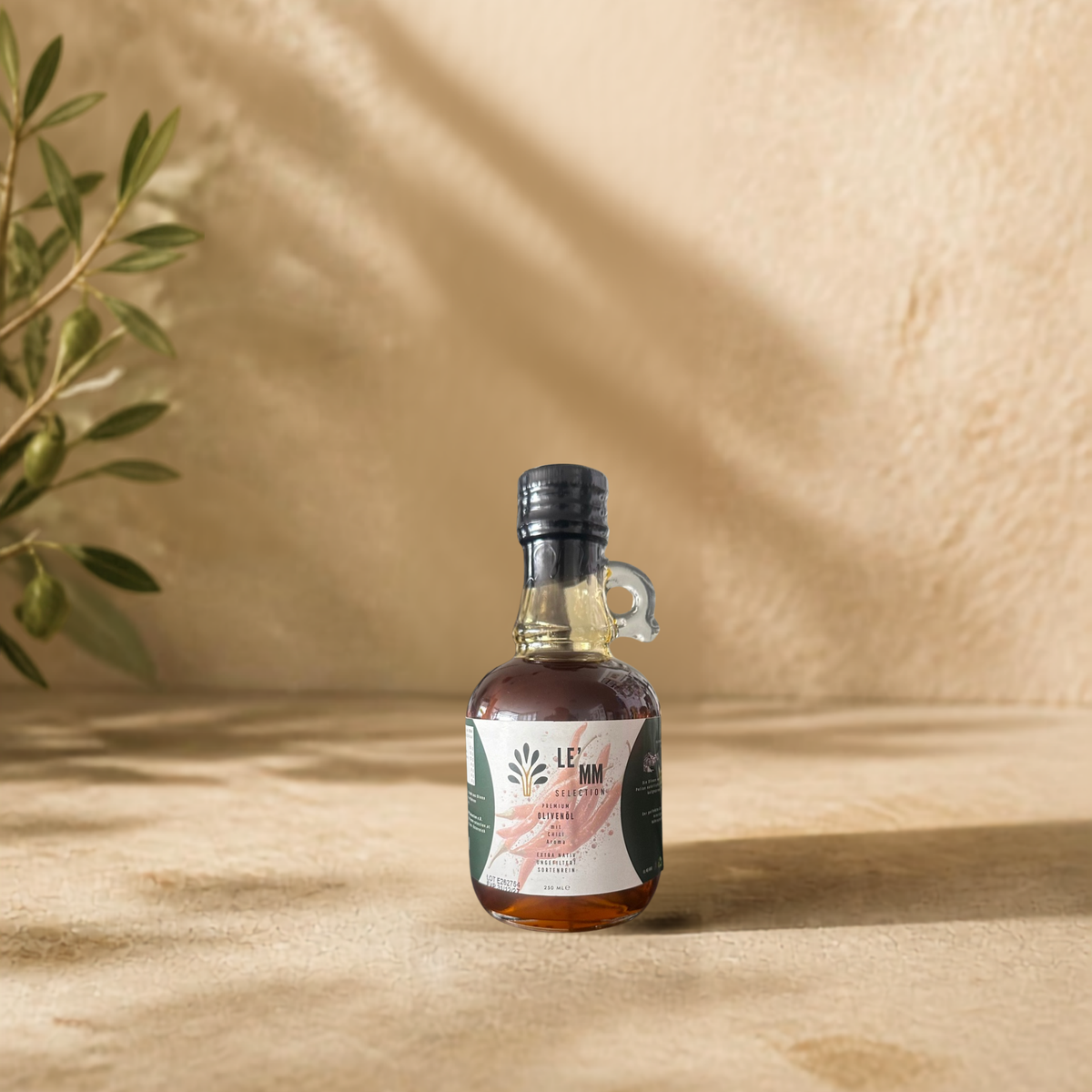 Griechisches Olivenöl Extra Nativ mit Chili Geschmack von LEMM Selection in mediterranem Ambiente mit Olivenzweig vorderseite