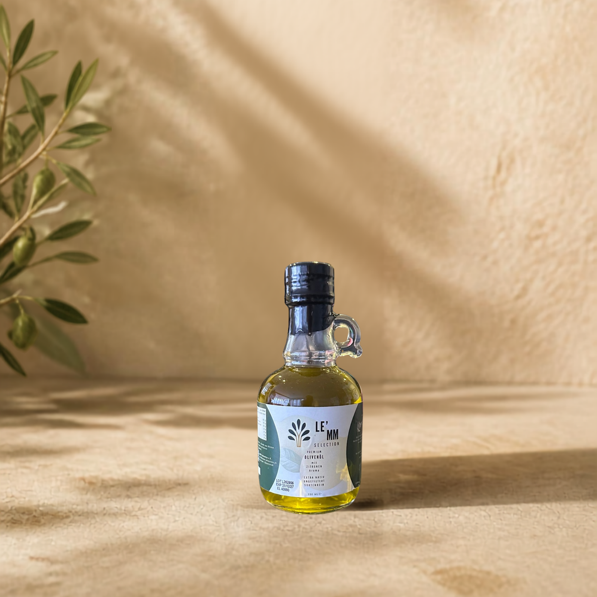 Griechisches Olivenöl Extra Nativ mit Zitrone Geschmack von LEMM Selection in mediterranem Ambiente mit Olivenzweig vorderseite